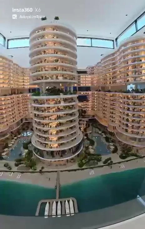 The architectural scale model of the AMRA development: curved residential towers around a lagoon and beach.