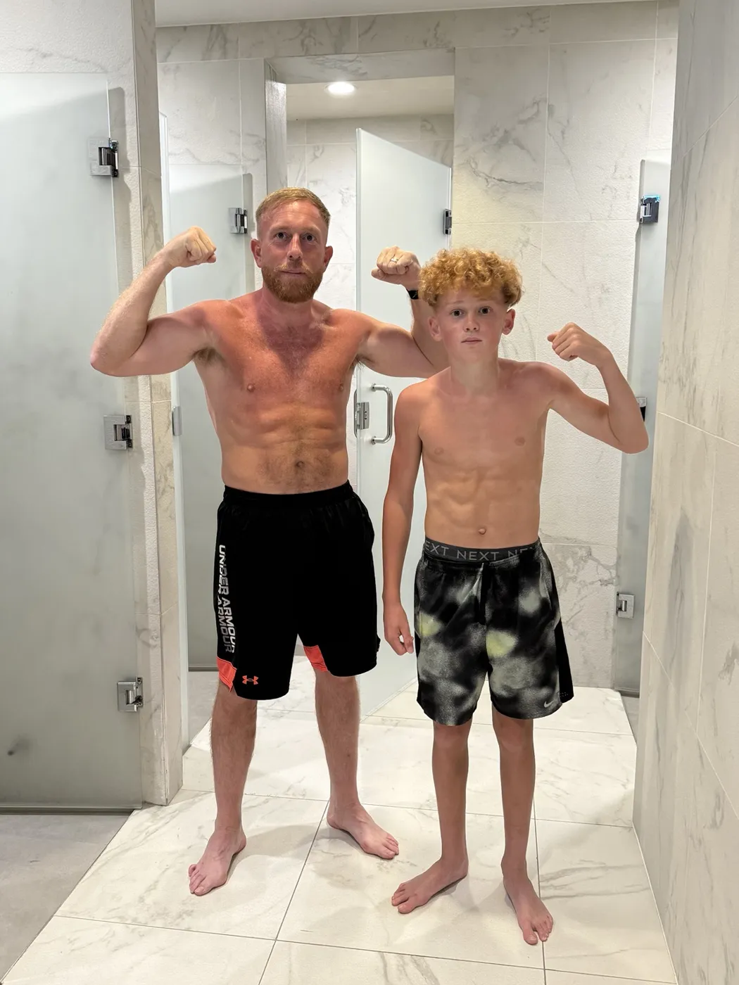 Bobby and his son flexing their arms side by side.