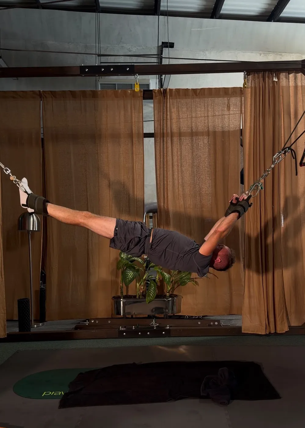 Bobby held horizontally in a Pravilo rig, straps at both wrists and ankles pulling in opposite directions.
